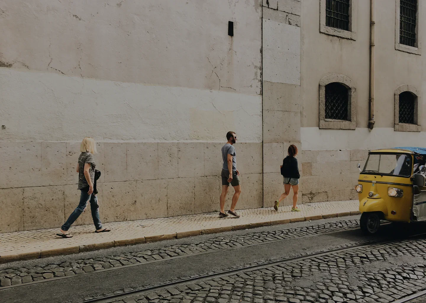 Travelers walking down an old cobblestone street with backpacks